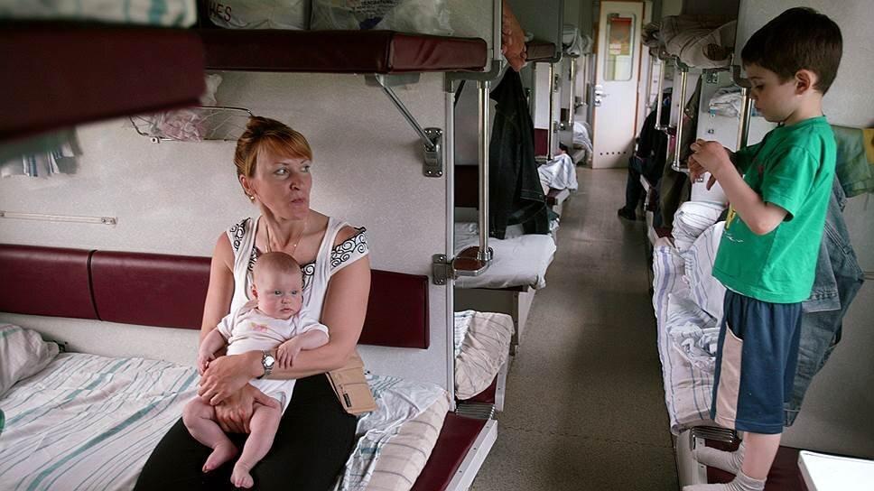 Семья с детьми в вагоне поезда.